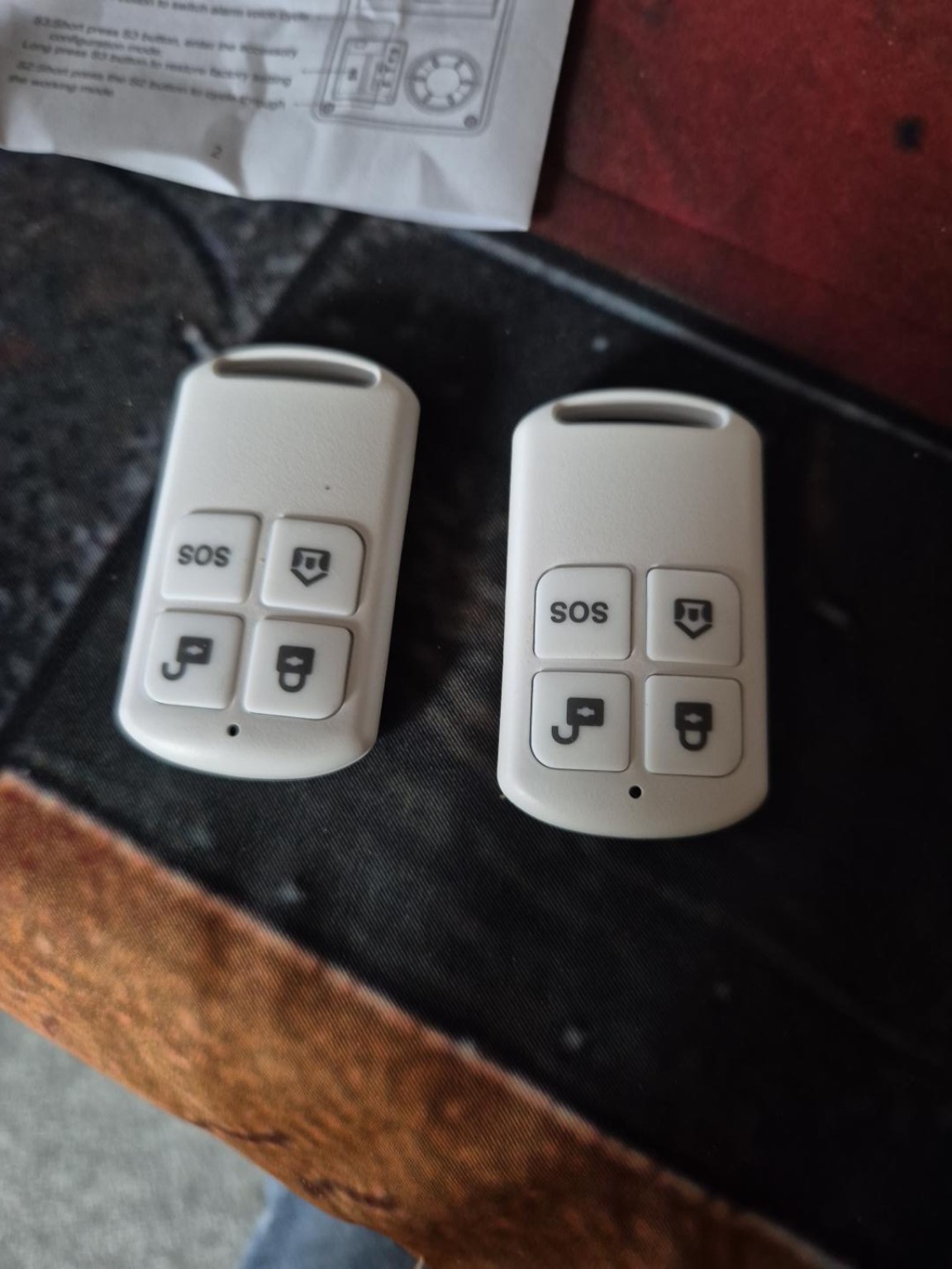 Two four-button alarm remote controls